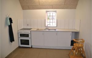 a kitchen with white cabinets and a sink and a window at Awesome Apartment In Nrre Nebel With 1 Bedrooms And Wifi in Stavsø
