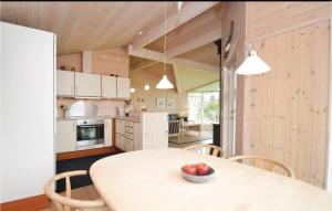 a kitchen with a table with a bowl of fruit on it at Holiday Home Elsdyrstien Ca Dnmk in Marielyst