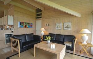 a living room with two black leather couches and a table at Holiday Home Elsdyrstien Ca Dnmk in Marielyst +11 photos