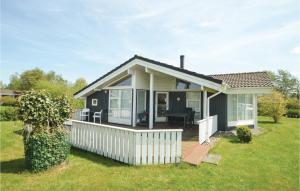 a small house with a porch and a deck at Gorgeous Home In Vggerlse With Wifi in Bøtø By