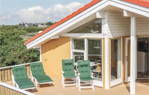 una terraza con sillas verdes en una casa en Buller, en Fanø