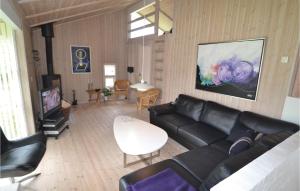 ブロックフスにあるBeautiful Home In Blokhus With Kitchenのリビングルーム(黒い革張りのソファ、テレビ付)
