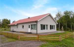 una pequeña casa blanca con una valla de madera en Amazing Home In Tidaholm With Kitchen en Gälleberg