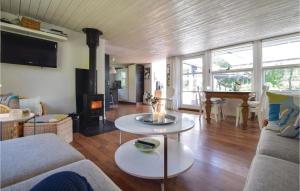 ヒュールスミンネにあるGorgeous Home In Juelsminde With Saunaのリビングルーム(ソファ、テーブル、暖炉付)
