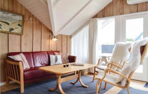 a living room with a red couch and a table at Holiday Home Hvide Sande 20 in Bjerregård +10 photos