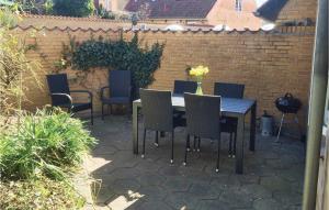 a patio with a table and chairs and a brick wall at Holiday Home Nysted Xcix in Nysted
