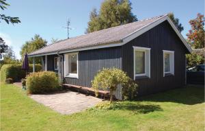 czarny dom z białymi oknami i dziedzińcem w obiekcie Amazing Home In Svendborg With Kitchen w mieście Vemmenæs