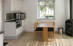 アリンエにあるAwesome Apartment In Allinge With Wifiのキッチン(テーブル、コンロ、窓付)
