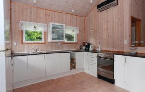 een keuken met witte kasten en houten wanden bij 2 Bedroom Nice Home In Vig in Vig