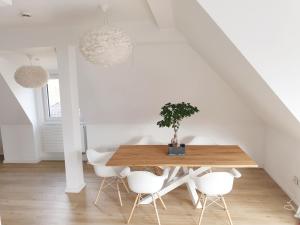 uma sala de jantar com uma mesa de madeira e cadeiras brancas em Wunderschönes Penthouse im Herzen von Hameln em Hameln