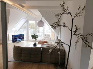 ein Wohnzimmer mit einem Sofa und einem großen Fenster in der Unterkunft Wunderschönes Penthouse im Herzen von Hameln in Hameln