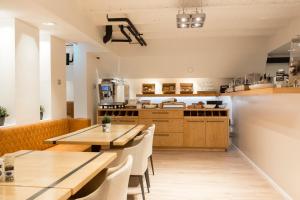 a restaurant with wooden tables and chairs and a kitchen at Hotel Marktzicht in Harderwijk