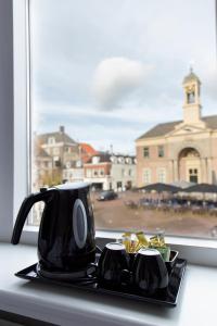 una cafetera negra sentada en un mostrador junto a una ventana en Hotel Marktzicht, en Harderwijk