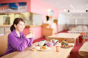 a woman sitting at a table with a plate of food at Kyukamura Iwate-Amiharionsen in Shizukuishi
