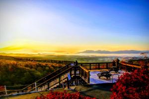 two people standing on a deck with a view of the mountains at Kyukamura Iwate-Amiharionsen in Shizukuishi