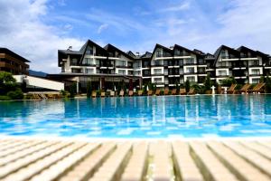 a large swimming pool in front of a building at Aspen Ski and Golf Resort in Bansko