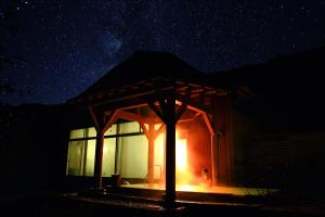 a small cabin with a lit up window at night at Kyukamura Iwate-Amiharionsen in Shizukuishi