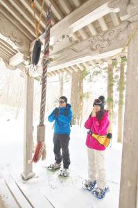 two people standing on skis in the snow at Kyukamura Iwate-Amiharionsen in Shizukuishi
