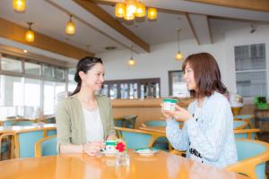 two women sitting at a table drinking coffee at Kyukamura Iwate-Amiharionsen in Shizukuishi