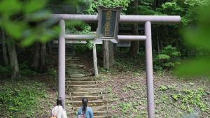 two people sitting on stairs in a japanese shrine at Kyukamura Iwate-Amiharionsen in Shizukuishi