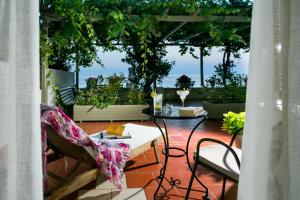 eine Terrasse mit einem Tisch, Stühlen und Pflanzen in der Unterkunft Kenta Beach Hotel in Agios Ioannis