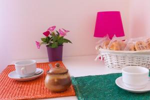 una mesa con tazas y platillos y una cesta de pan en Cri&Gio, en Sorrento