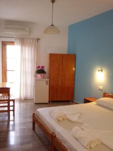 een slaapkamer met een bed en een blauwe muur bij Sunrise House in Parga