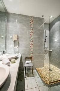 W łazience znajduje się wanna, umywalka i prysznic. w obiekcie Hôtellerie Beau Rivage w mieście Condrieu