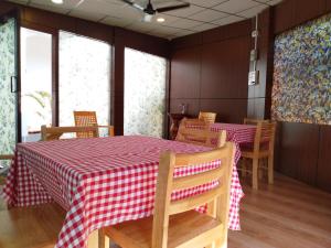 d'une salle à manger avec deux tables avec un chiffon rouge et blanc. dans l'établissement Kevins Homestay, à Port Blair