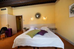 a bedroom with a white bed with a mirror on the wall at Hôtellerie Beau Rivage in Condrieu