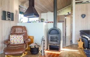 a living room with a wood stove and a chair at Holiday Home Søndervang Hejls in Hejls