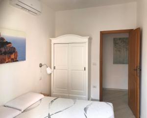 1 dormitorio con cama y armario blanco en Home Feeling Mascagni - Bilocale en Alguer