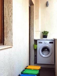 a laundry room with a washing machine and a window at Home Feeling Mascagni - Bilocale in Alghero