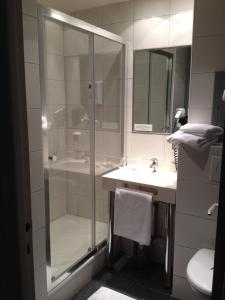 ein Bad mit einer Dusche und einem Waschbecken in der Unterkunft LES ARCADES in Dieppe