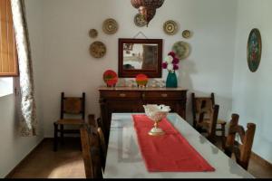 ein Esszimmer mit einem Tisch, Stühlen und einem Spiegel in der Unterkunft El olivar de Concha, Caminito del Rey in Alora
