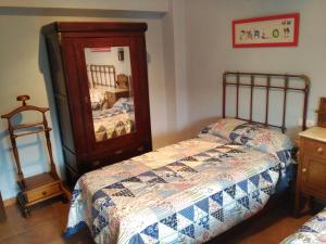 a bedroom with a bed and a dresser and a mirror at El olivar de Concha, Caminito del Rey in Alora