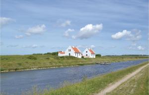 a couple of white houses on the side of a river at Amazing Home In Lgstr With 2 Bedrooms in Løgstør