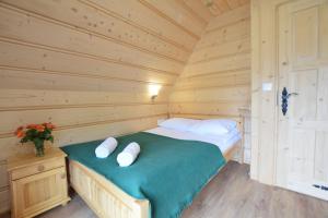 a bedroom with a bed in a log cabin at Witowianskie Domki Private Jacuzzi & Mountain View near Zakopane in Dzianisz