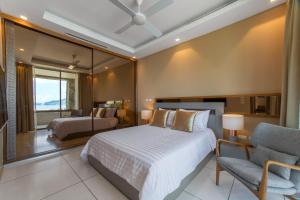 1 dormitorio con cama, silla y espejo en Villa Skyfall Thailand Phuket, en Panwa Beach