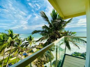 a balcony with a view of the ocean and palm trees at Rockholm at the Light House Beach in Kovalam