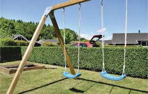 two swings in a yard next to a hedge at Holiday Home Pøt Strandby Juelsminde Q in Sønderby +15 photos