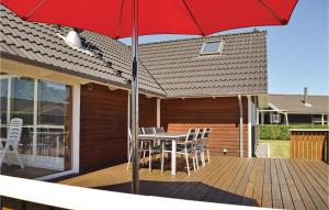 a patio with a table and chairs and an umbrella at Holiday Home Pøt Strandby Juelsminde Q in Sønderby