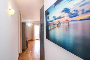 a hallway with a large painting of a pier at VVROMPEOLAS in Puerto de Mogán +2 photos