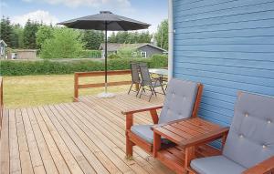 una terrazza in legno con due sedie e un ombrellone di Holiday Home Bjergvej Hejls Iv a Hejls Altre 7 foto