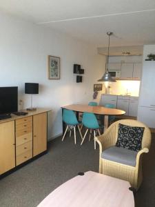 een woonkamer met een keuken en een tafel en stoelen bij Zuiderzeestate 28 in Makkum