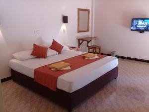 a hotel room with a large bed with a television at Kithmi Resort in Polonnaruwa