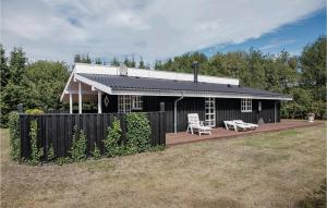a black house with a porch and a bench at Holiday Home Harvigs Strandpark in Haslevgårde