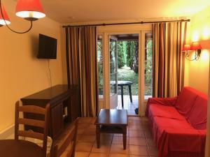 un salon avec un canapé rouge et une table dans l'établissement Studio 4 personnes Villa Maldagora Ciboure (St jean de Luz/Soccoa), à Ciboure