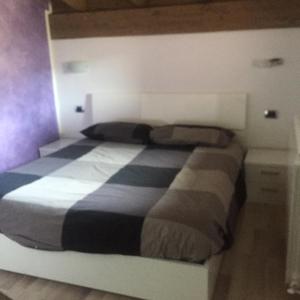 a bedroom with a bed with a black and white blanket at incantevole in Malonno