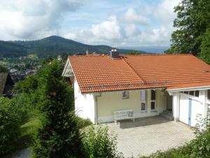 een wit huis met een oranje tegeldak bij Ferienhaus Feist in Bodenmais